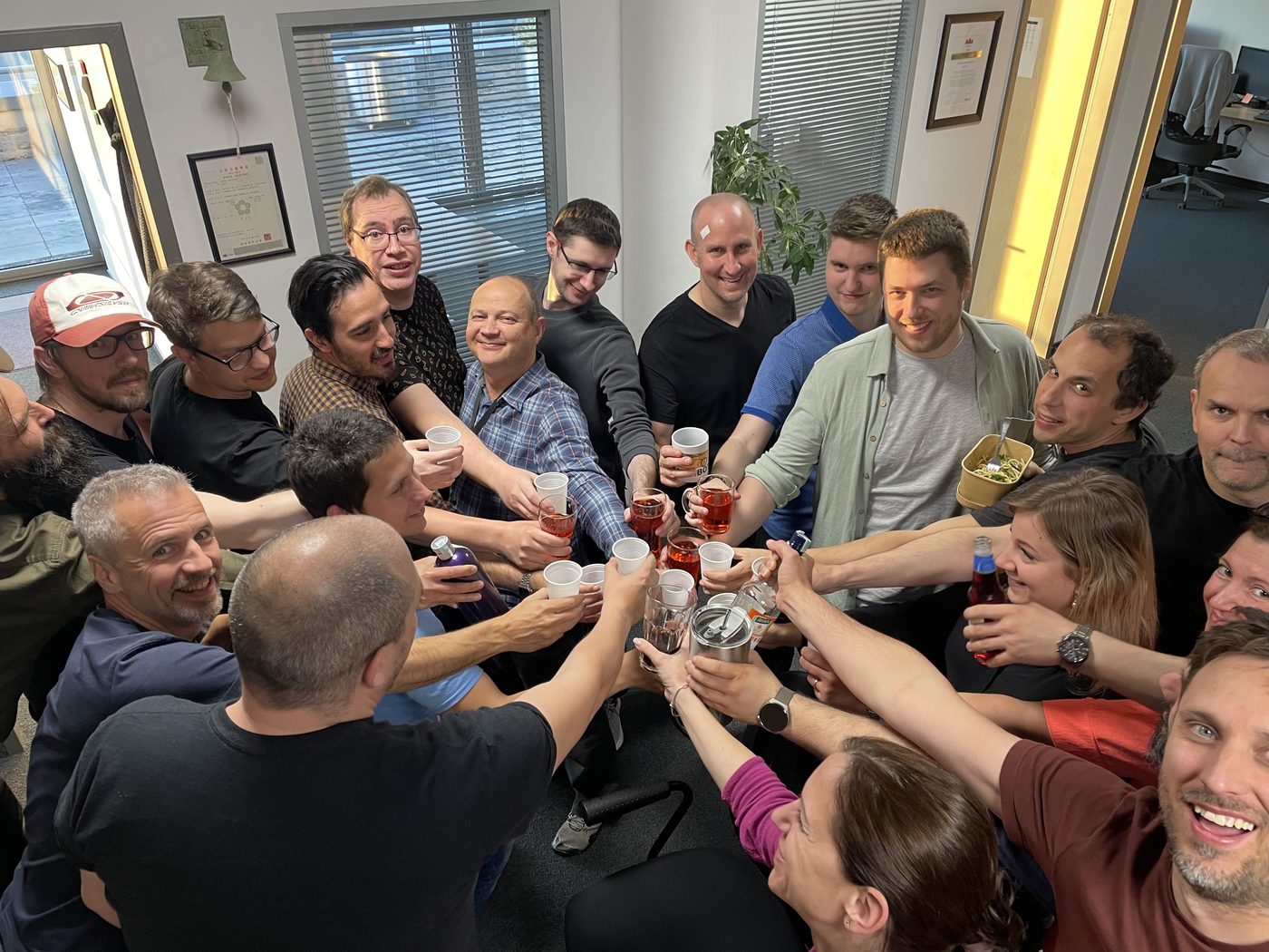 The Arenim team raising a toast together in the Arenim office, 2025